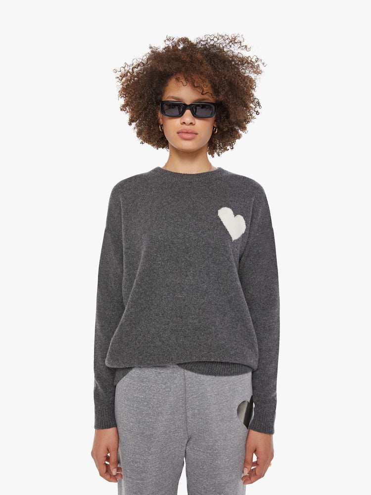 Front view of a woman in a sweater  cashmere in dark grey, the sweater has a crewneck, drop shoulders and a loose, comfortable fit.