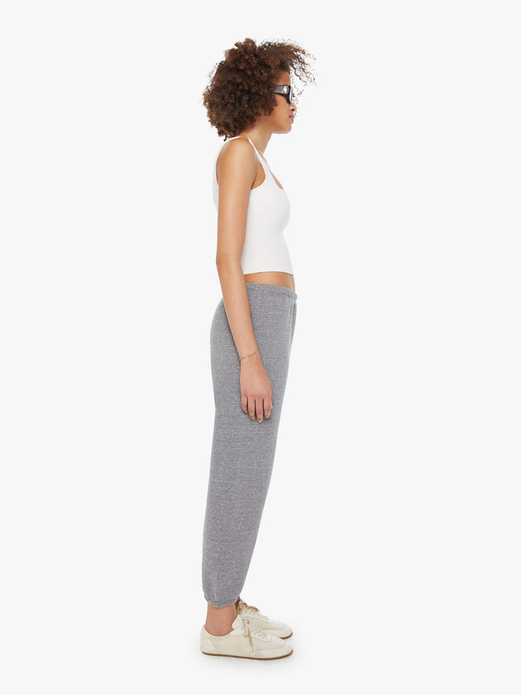 Side view of a woman in a black heart on the hip grey sweatpants with an elastic waist and cuffs for a loose, comfortable fit. 