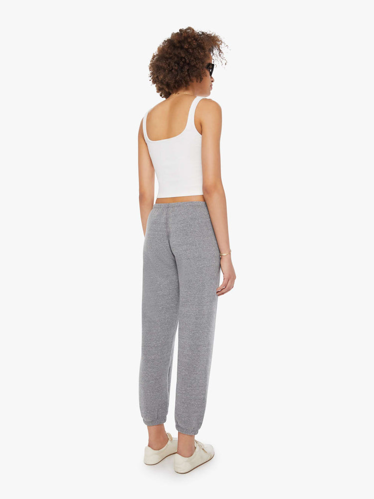 Back view of a woman in a black heart on the hip grey sweatpants with an elastic waist and cuffs for a loose, comfortable fit. 