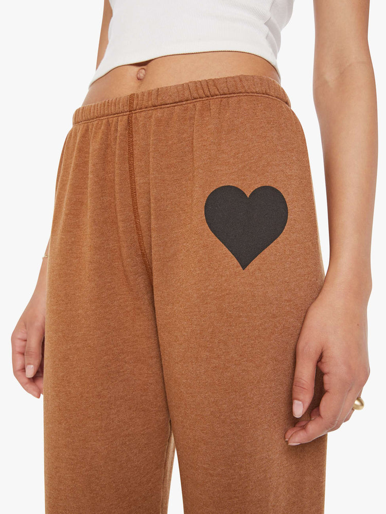 Close up  view of a woman in a khaki sweatpant with a black heart and an elastic waist and cuffs for a loose.