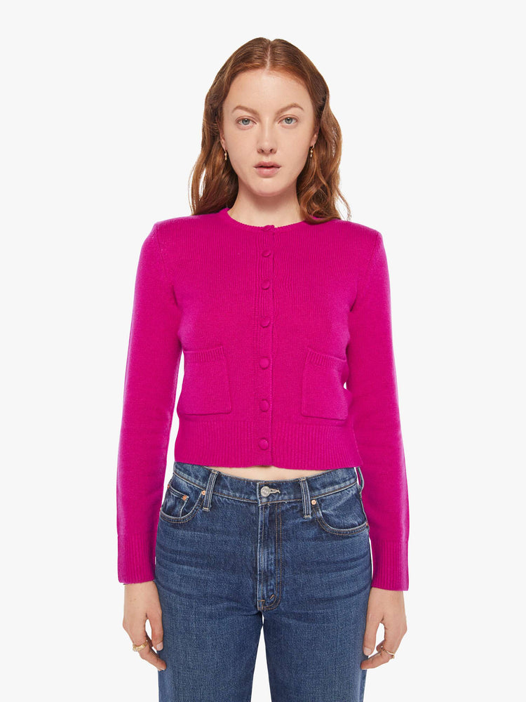 Front view of a woman in a magenta cardigan with tonal buttons down the front.