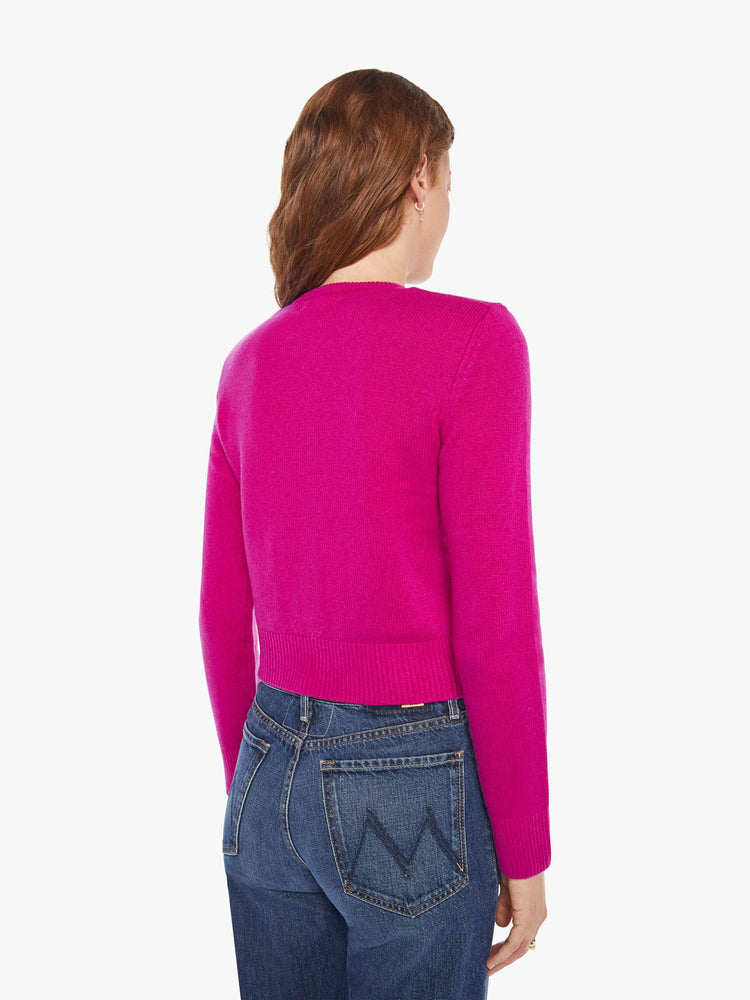 Back view of a woman in a magenta cardigan with tonal buttons down the front.