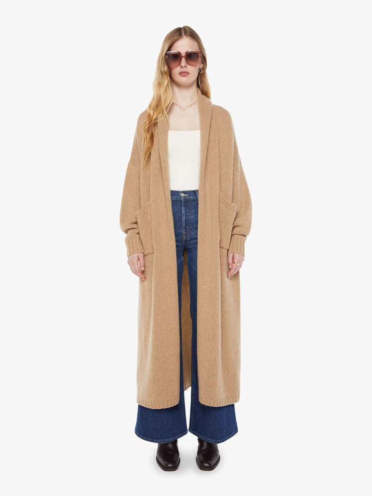 Front view of woman in a light khaki  knit duster with a shawl collar, optional tie belt and ankle-length hem. 