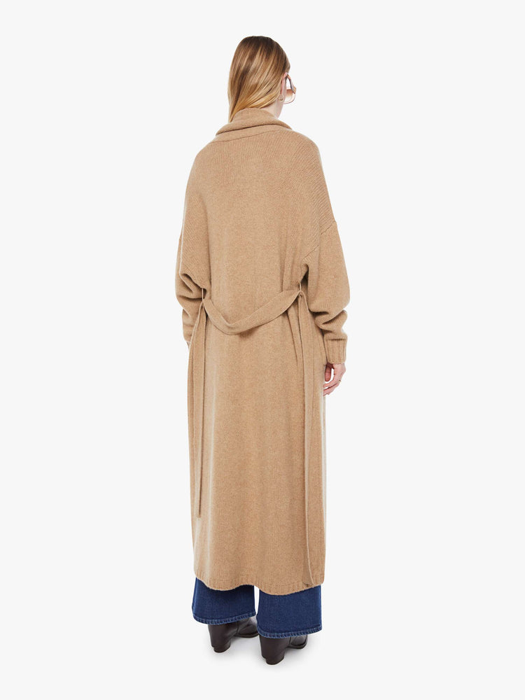 Back view of woman in a light khaki  knit duster with a shawl collar, optional tie belt and ankle-length hem. 
