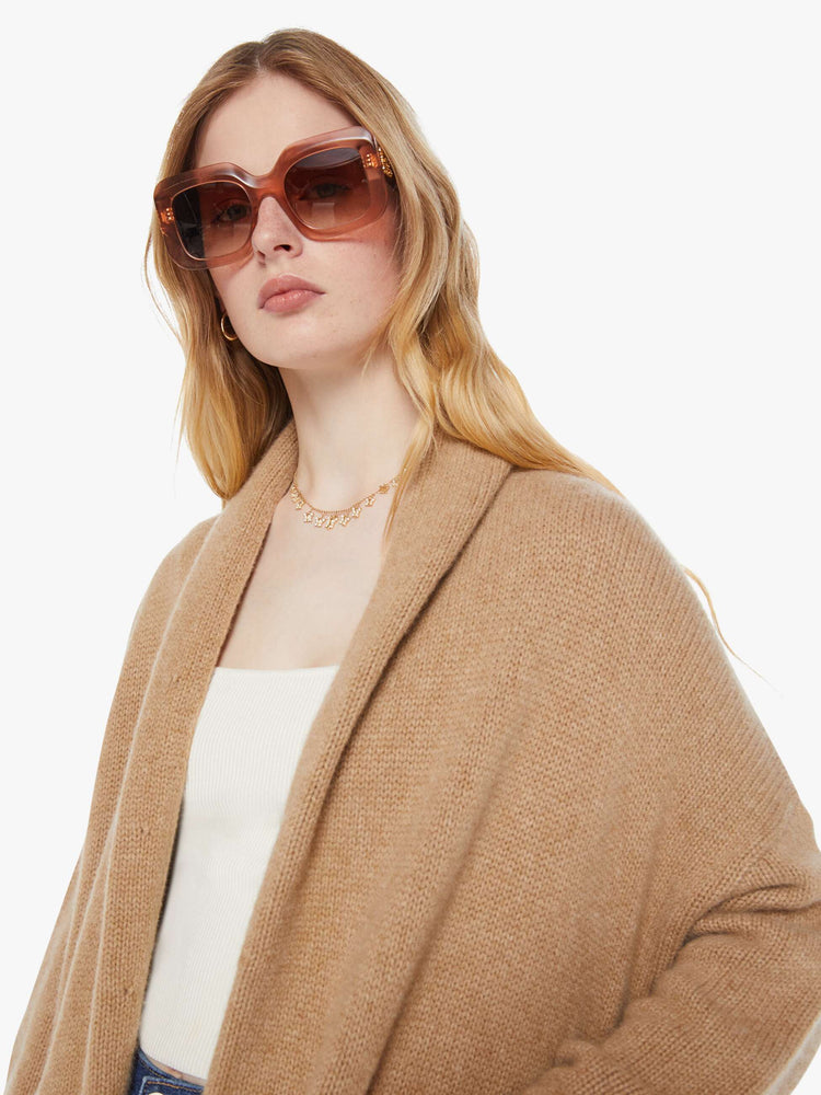 Close up view of woman in a light khaki  knit duster with a shawl collar, optional tie belt and ankle-length hem. 