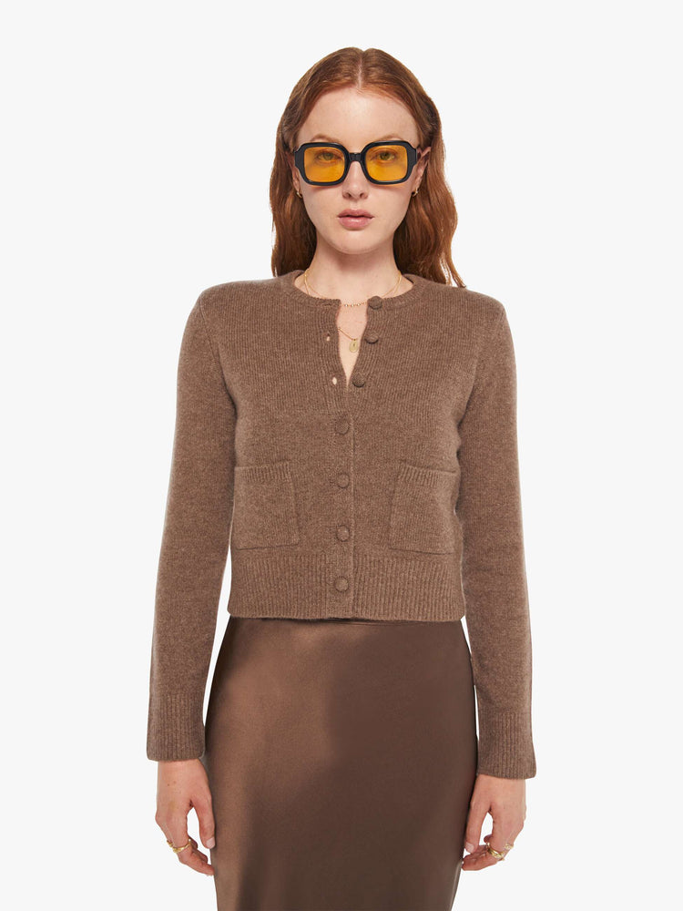 Front view of a woman in a cashmere chocolate brown cardigan with tonal buttons down the front.