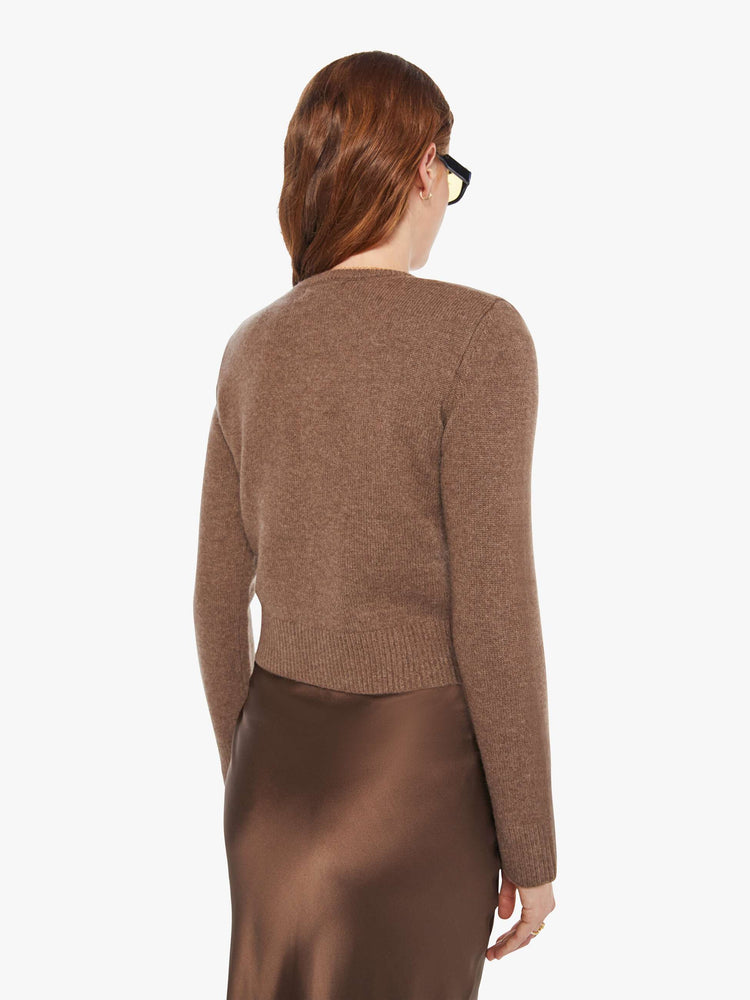 Back view of a woman in a cashmere chocolate brown cardigan with tonal buttons down the front.