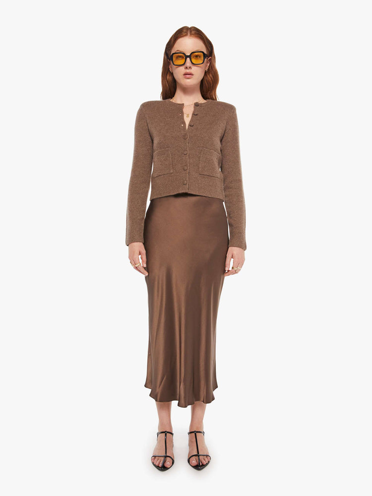 Front view of a woman in a cashmere chocolate brown cardigan with tonal buttons down the front.