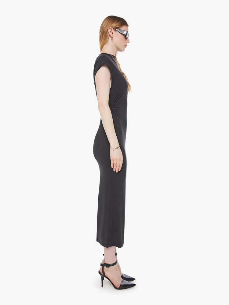 Side view of a woman in a black midi dress designed with a mock neck, short sleeves, a narrow fit and calf-grazing hem.