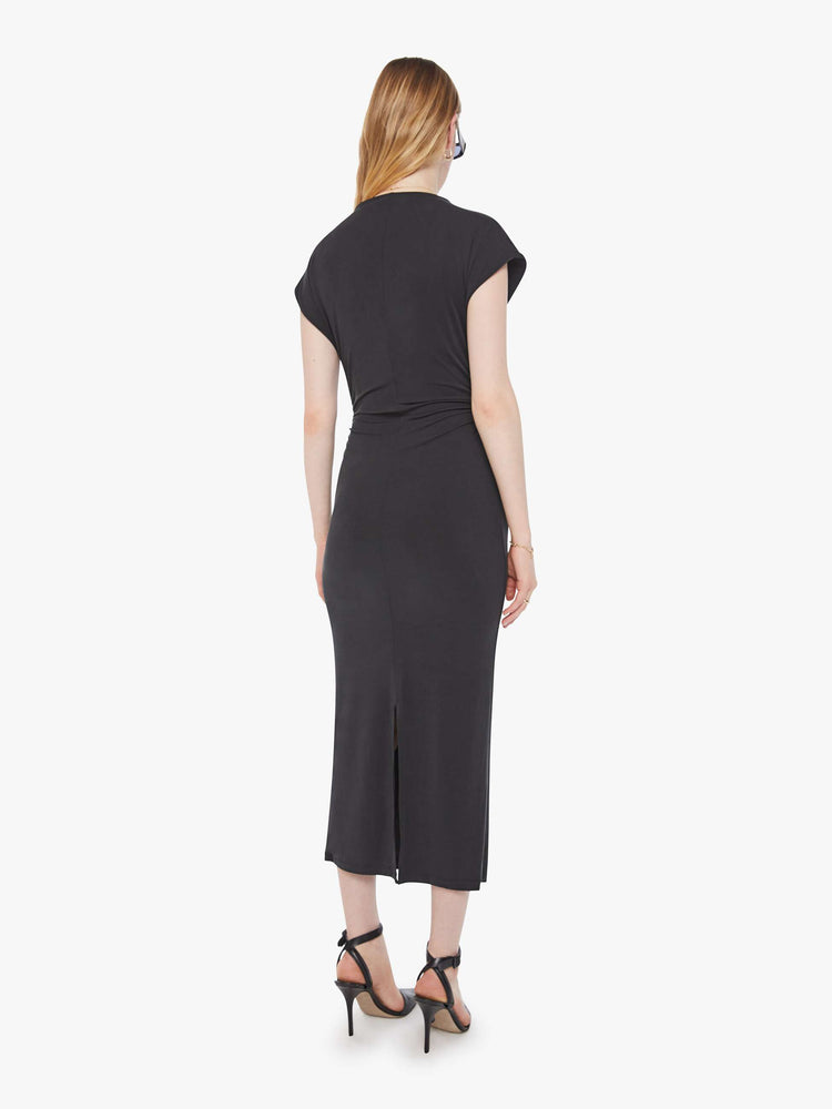 Back view of a woman in a black midi dress designed with a mock neck, short sleeves, a narrow fit and calf-grazing hem.
