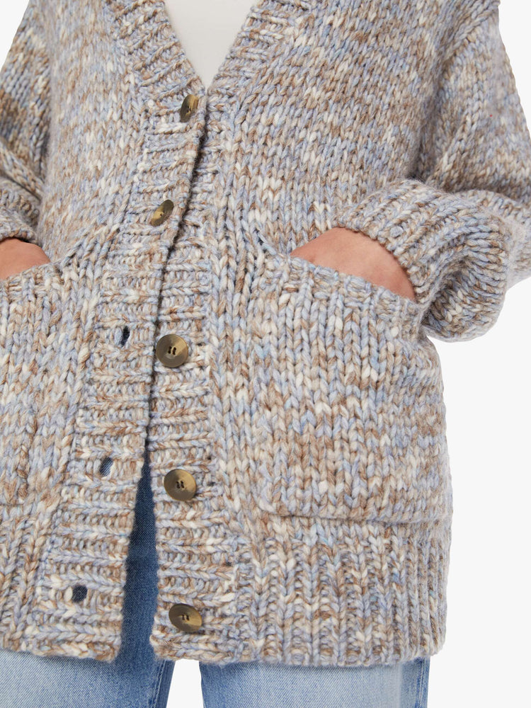 Swatch view of a woman in a  grey, baby blue and white mélange, the cardigan has a deep V-neck, drop shoulders, buttons down the front and thick ribbed hems.