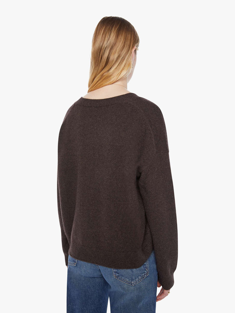 Back view of a woman in a rich brown sweater is designed with a deep V-neck, drop shoulders, long sleeves and a slightly oversized fit.