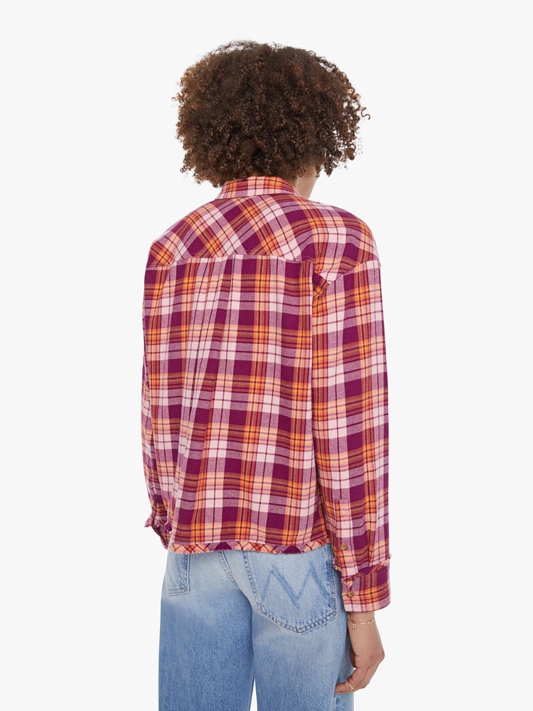 Back view of a woman in an orange and hot pink plaid long-sleeve shirt with patch pockets, drop shoulders and a slightly cropped fit.