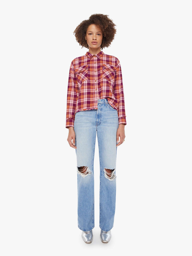 Full body view of a woman in an orange and hot pink plaid long-sleeve shirt with patch pockets, drop shoulders and a slightly cropped fit.