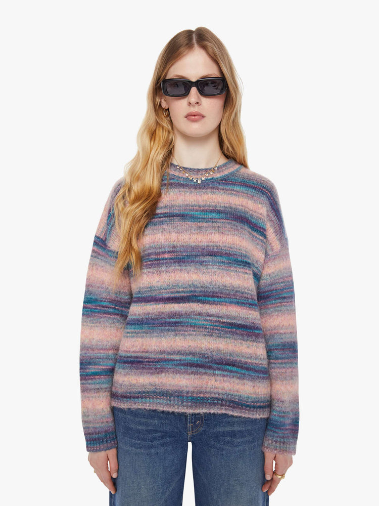 Front view of a woman in a pink and blue stripes the long-sleeve sweater with drop shoulders and an oversized fit.