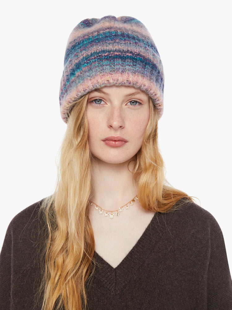 On model of a pink and blue stripes beanie features an extra-wide ribbed brim and an oversized fit.