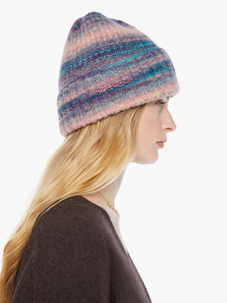 Side model of a pink and blue stripes beanie features an extra-wide ribbed brim and an oversized fit.