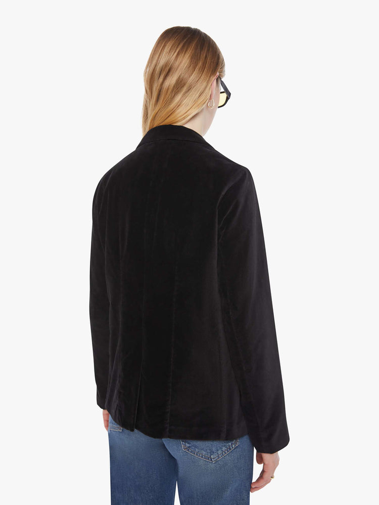 Back view of a woman in a black blazer is designed with a notched collar, deep V-neck, single-button closure and a slightly boxy fit.