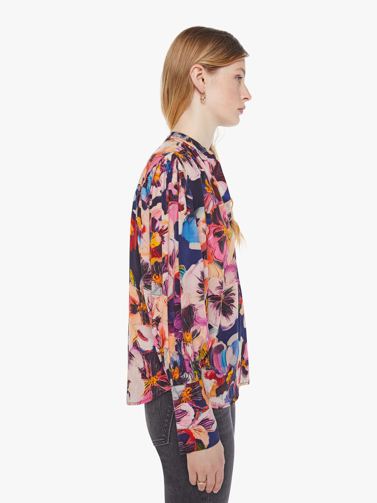 Side view of a woman in oversized floral print top with a V-neck, dropped shoulders and a slightly cropped fit.
