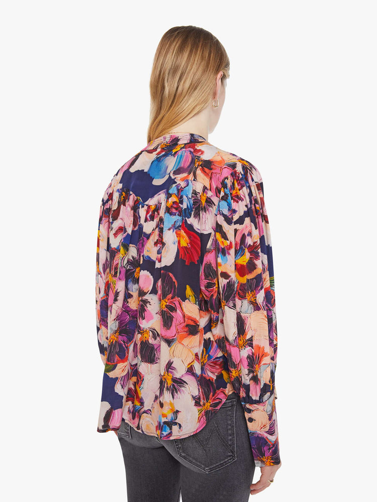 Back view of a woman in oversized floral print top with a V-neck, dropped shoulders and a slightly cropped fit.
