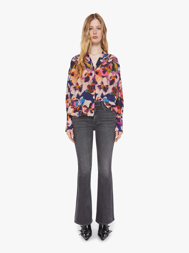 Full body view of a woman in oversized floral print top with a V-neck, dropped shoulders and a slightly cropped fit.