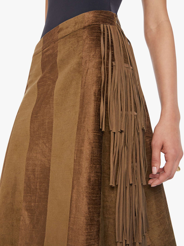 Close up view of a woman in a sage skirt with a high rise, fringe down the sides and a loose, flowy fit. 