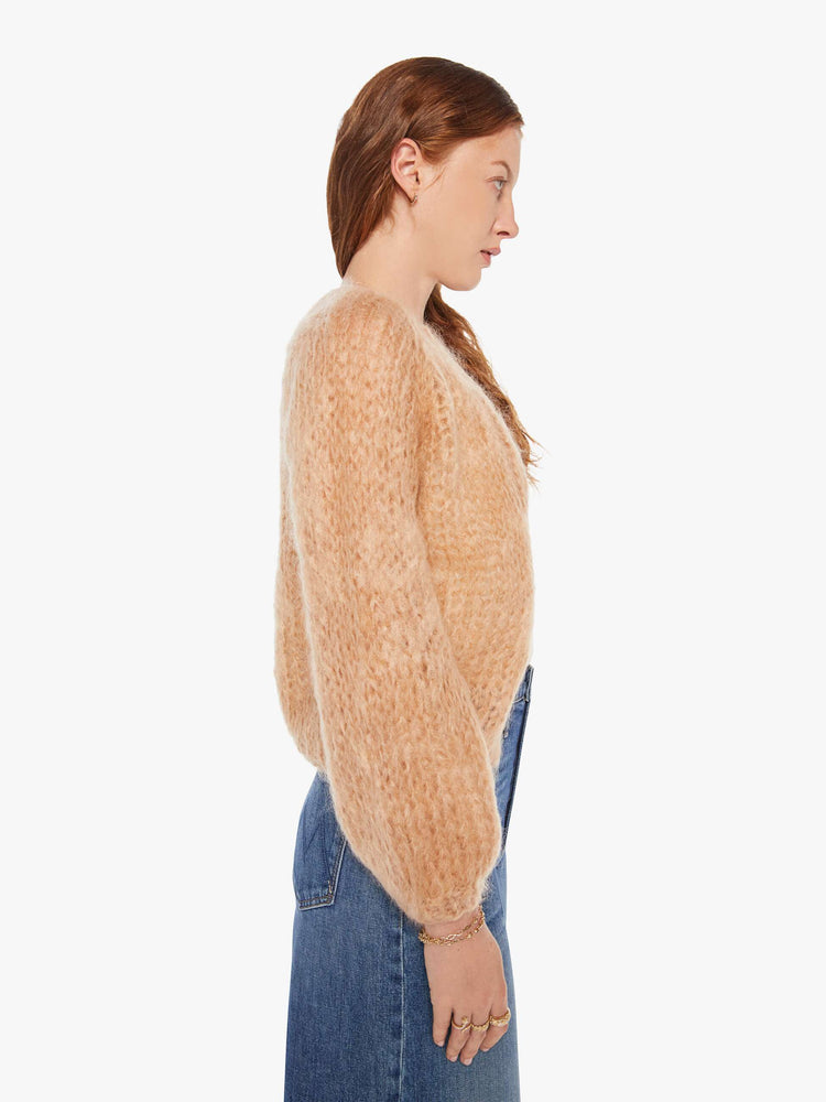Side view of a woman in a camel cardigan.