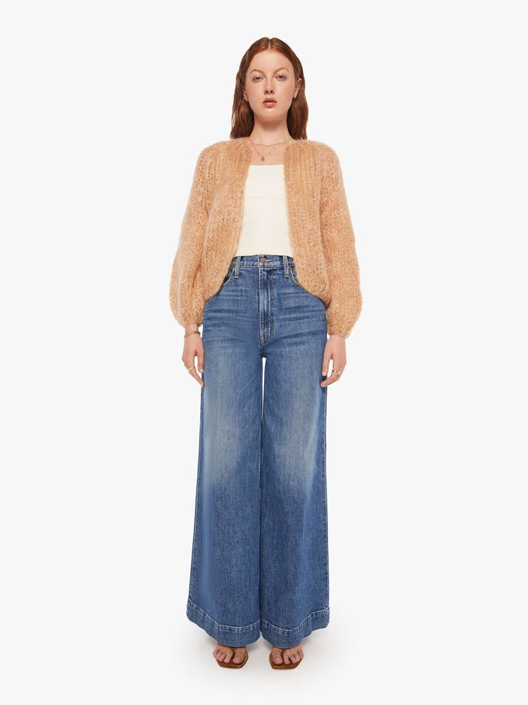 Full body view of a woman in a camel cardigan.