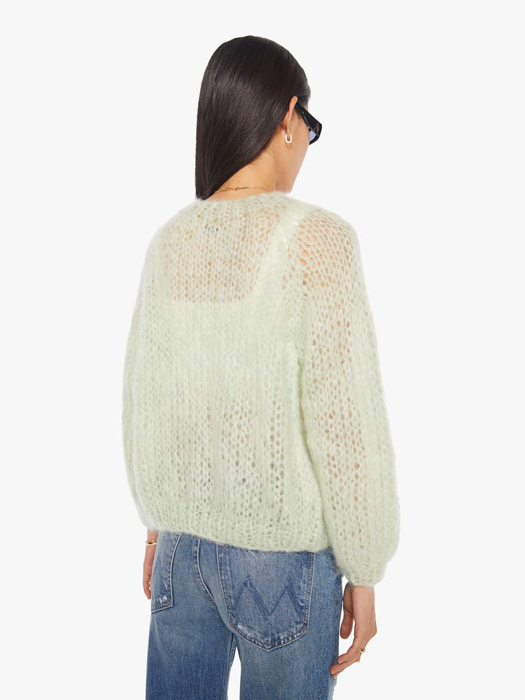Back view of a woman in a mint green cardigan.