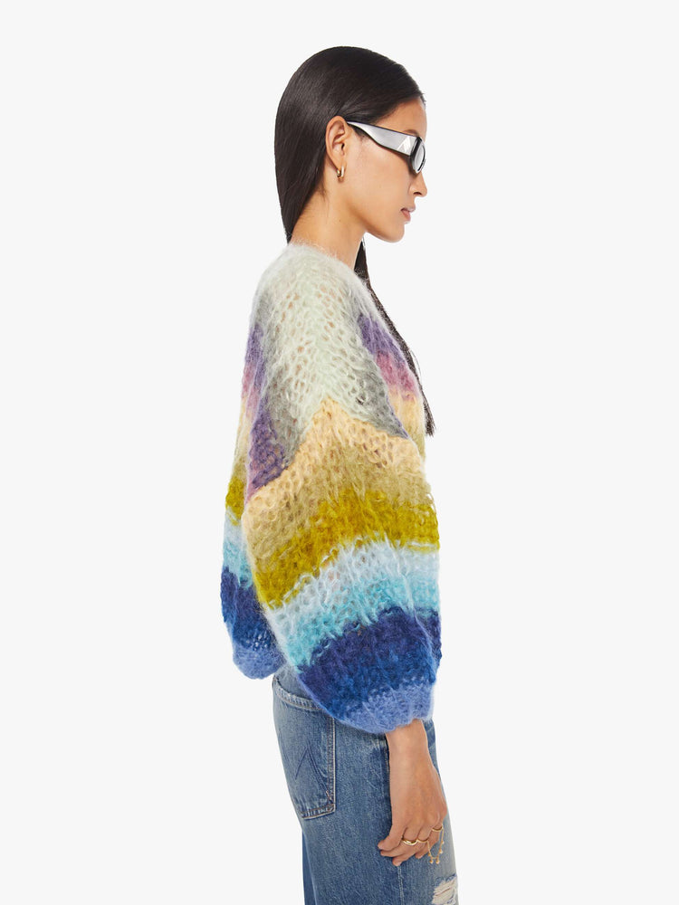 Side  view of a woman in  ribbed cardigan is hand knit from a soft blend of mohair and wool in a multicolor horizontal stripe pattern