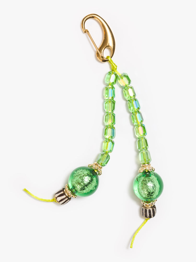 Flat view of a green keychain with a combination of glass, bone, acrylic and gold-plated beads.
