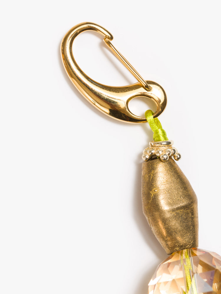 Clasp view of keychain with a large sundial shell and beads made from brass, glass crystal and wood. 