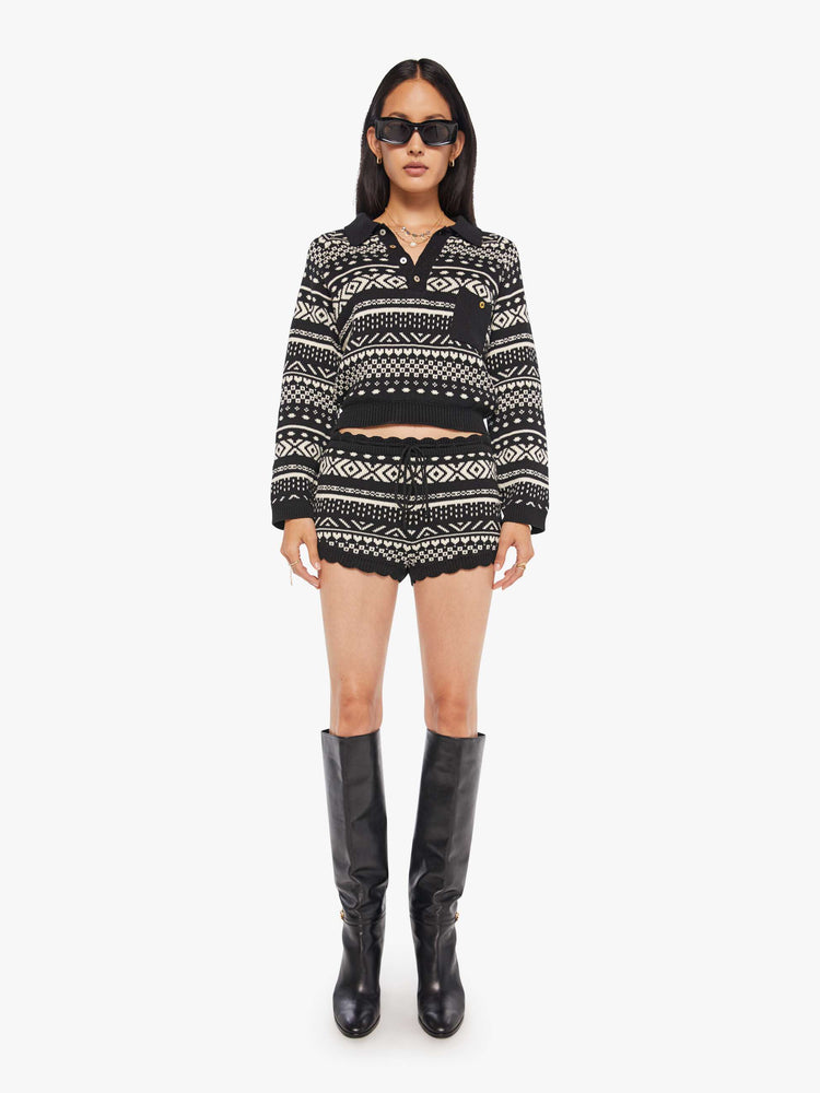 Front view of a woman in a black and off-white cable knit-inspired design, and feature a drawstring waistband, scalloped hems and an extra-short fit.