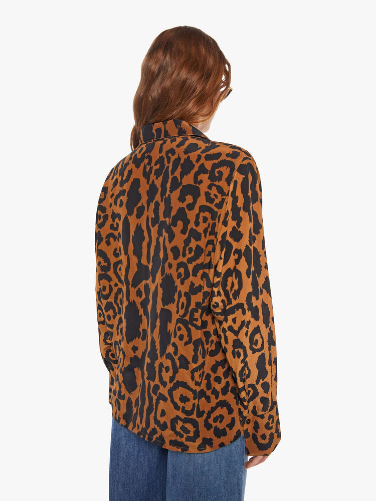 Back view of a woman in a button up leopard print, and features long balloon sleeves and a loose fit.