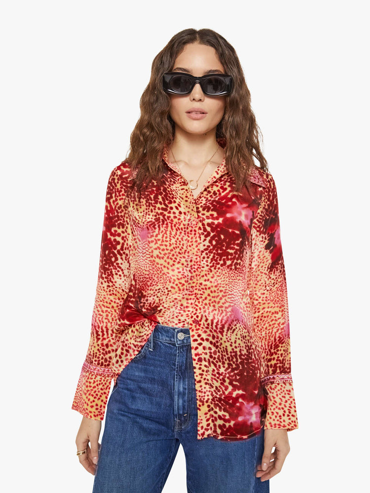 Front view of a woman in a top with abstract pink floral print with a V-neck, long sleeves and a narrow fit.