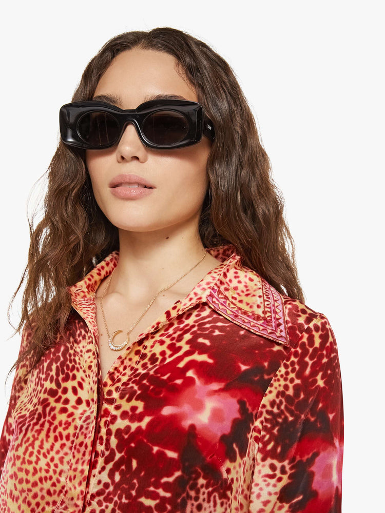 Swatch view of a woman in a top with abstract pink floral print with a V-neck, long sleeves and a narrow fit.