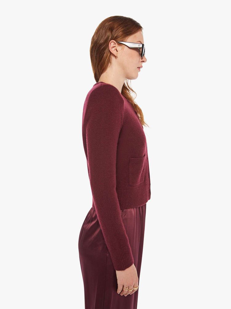 Side view of a woman in a silk, cashmere and leather, with a cropped hem and slightly shrunken fit cardigan.