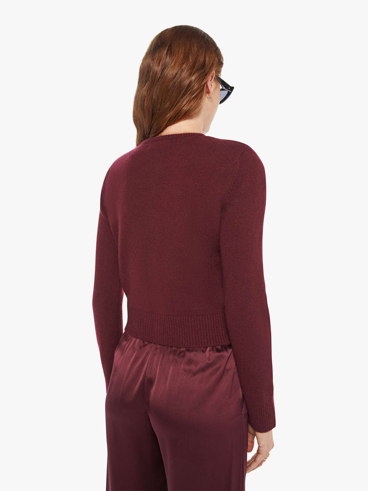 Back view of a woman in a silk, cashmere and leather, with a cropped hem and slightly shrunken fit cardigan.
