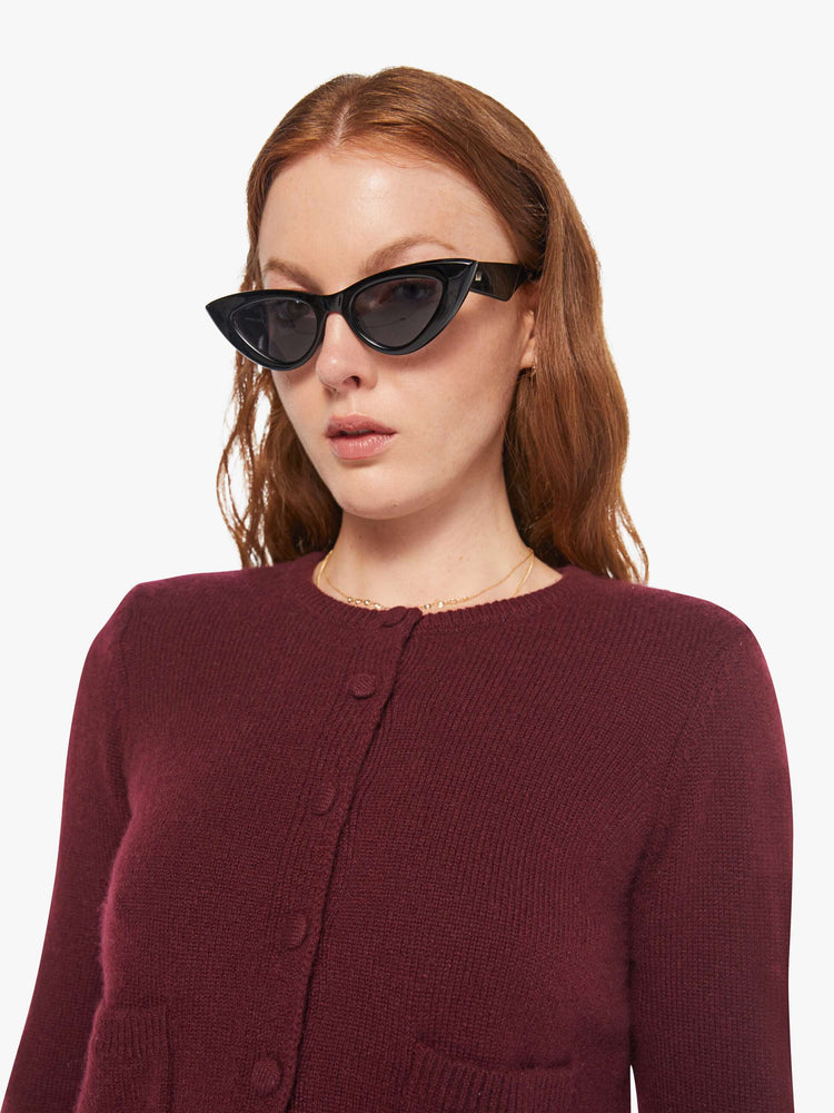 Close up view of a woman in a silk, cashmere and leather, with a cropped hem and slightly shrunken fit cardigan.