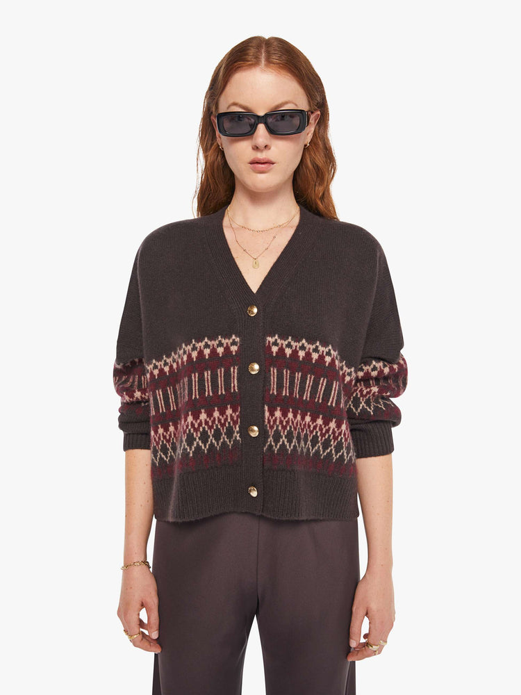 Front view of a woman in a brown with cream and bordeaux knit details cardigan.