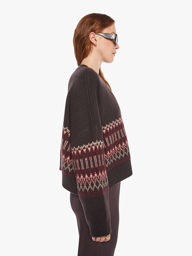 Side view of a woman in a brown with cream and bordeaux knit details cardigan.