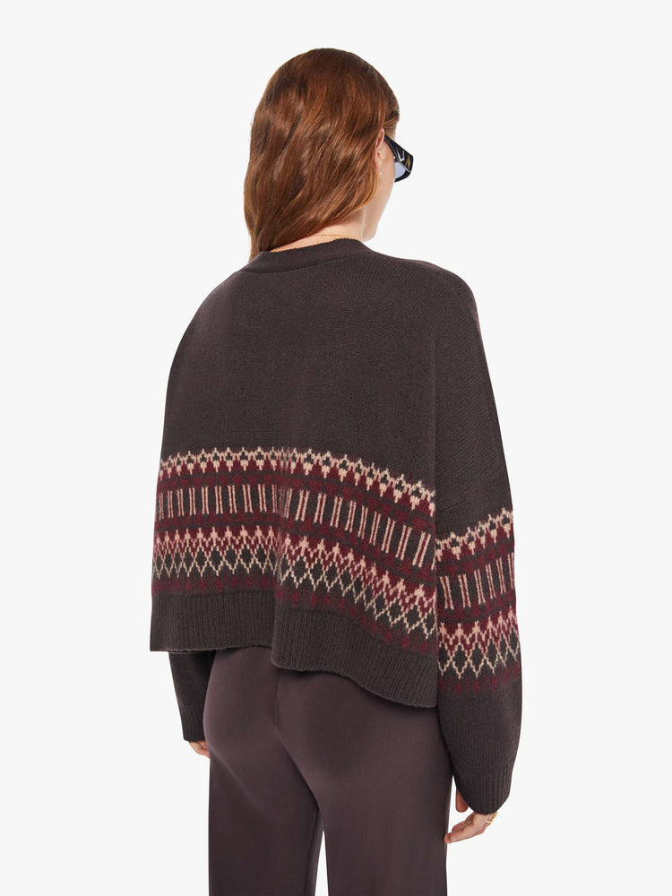 Back view of a woman in a brown with cream and bordeaux knit details cardigan.
