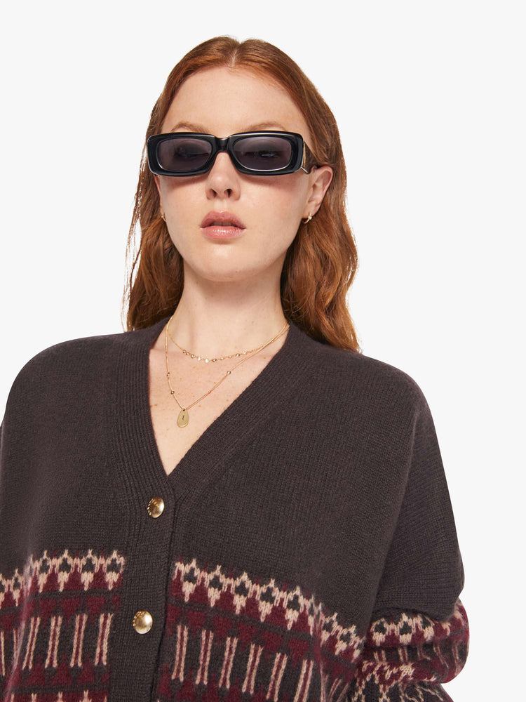 Close up view of a woman in a brown with cream and bordeaux knit details cardigan.