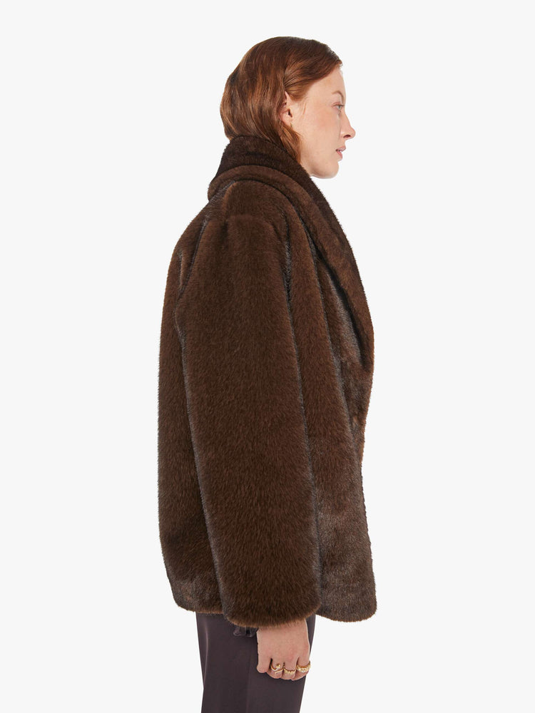 Side view of a woman in an oversized blazer in brown faux fur.
