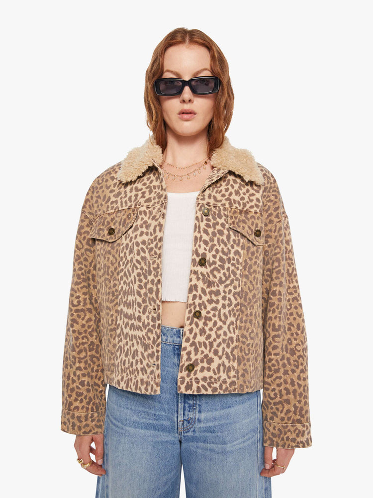 Front view of a woman in a cheetah print jacker with a faux-shearling collar, patch pockets, buttons down the front and a boxy, oversized fit.