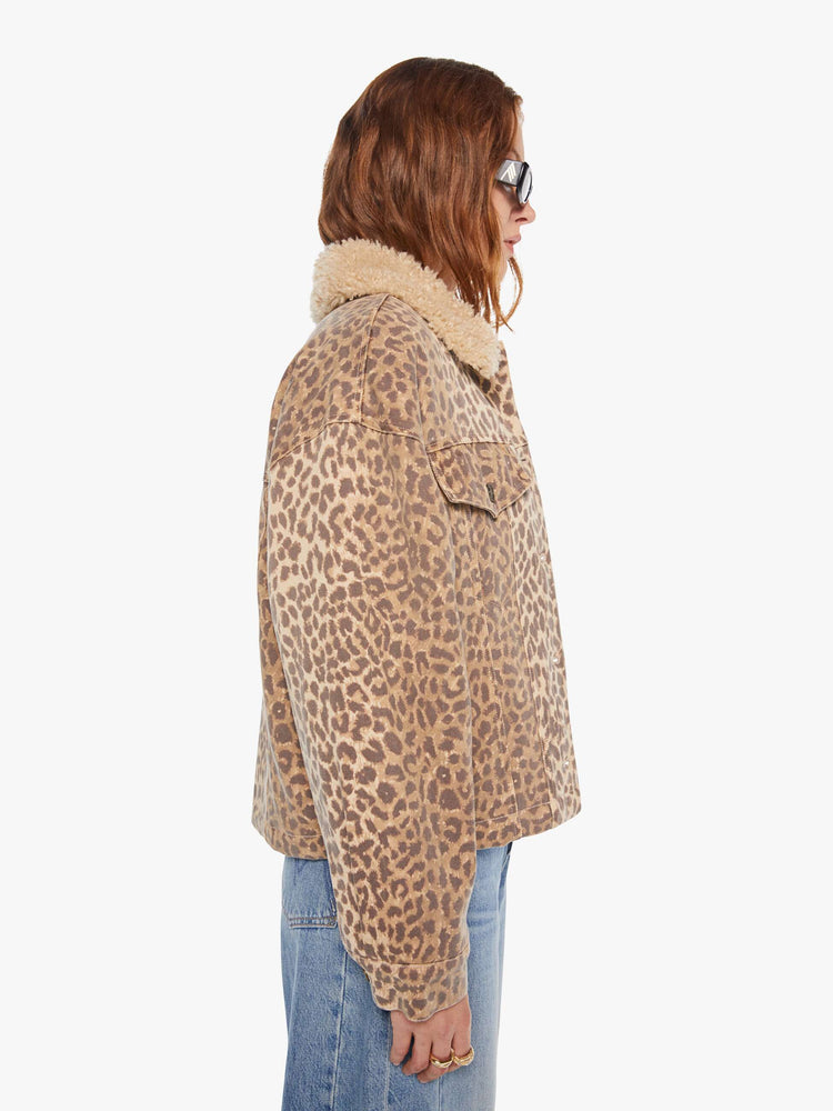 Side  view of a woman in a cheetah print jacker with a faux-shearling collar, patch pockets, buttons down the front and a boxy, oversized fit.
