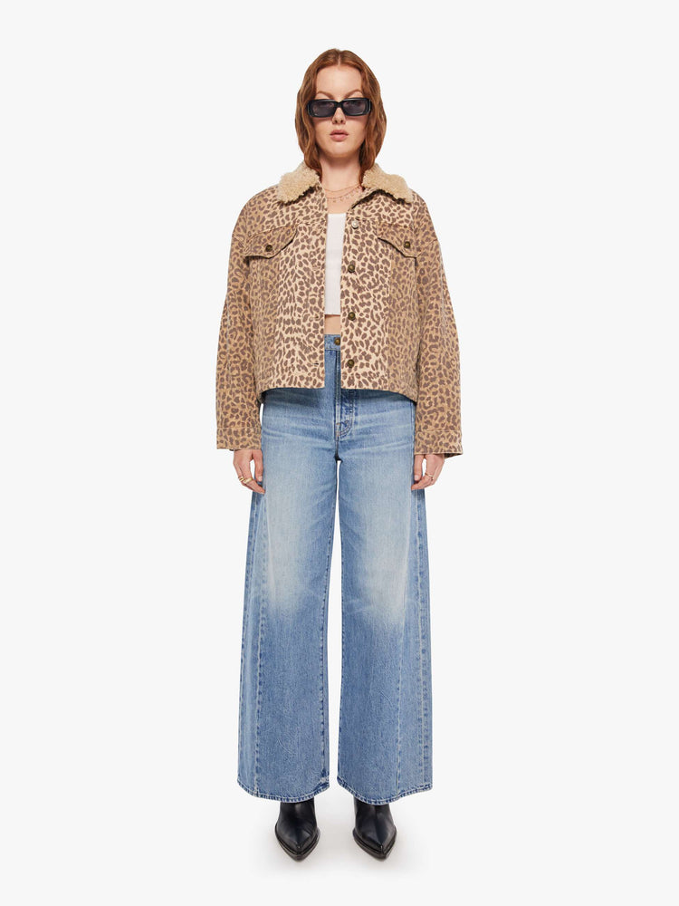 Full body  view of a woman in a cheetah print jacker with a faux-shearling collar, patch pockets, buttons down the front and a boxy, oversized fit.