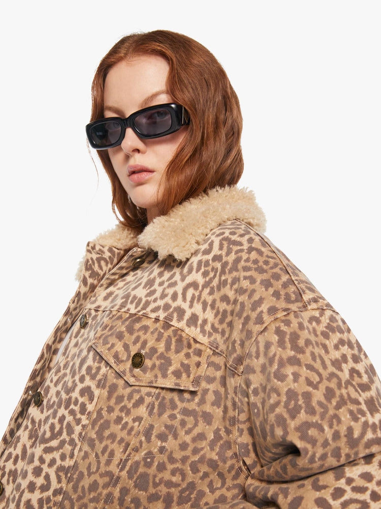Close up  view of a woman in a cheetah print jacker with a faux-shearling collar, patch pockets, buttons down the front and a boxy, oversized fit.