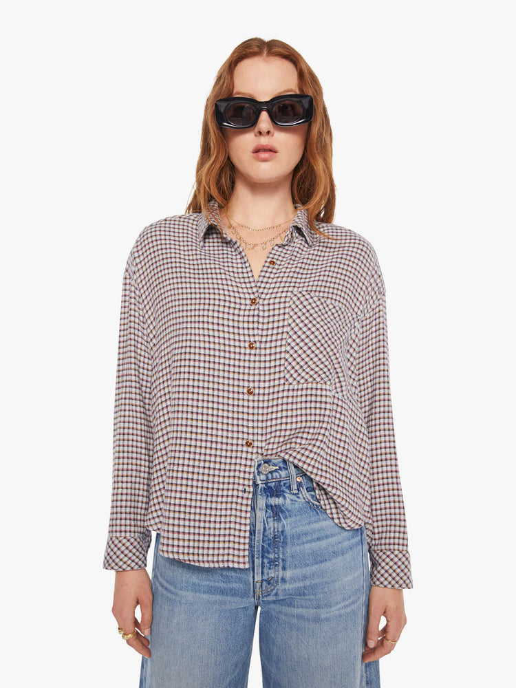 Front view of a woman in a white and baby blue checker print long sleeve shirt is designed with drop shoulders, a front patch pocket, curved hem and slightly cropped fit.