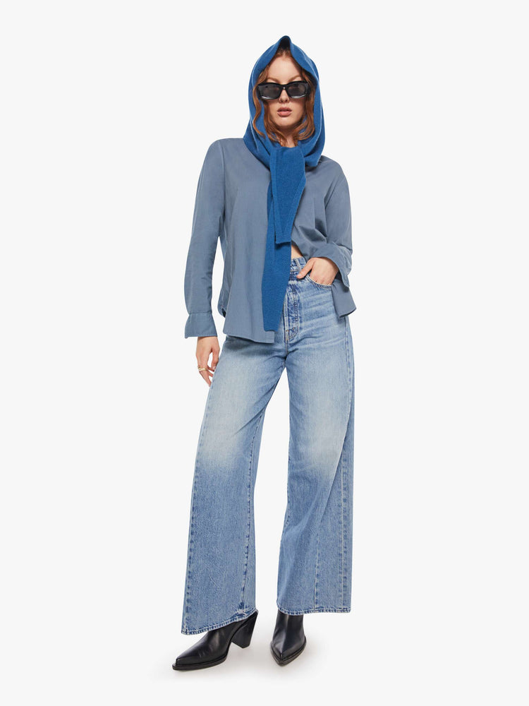 Full body on model view of a model in a cashmere blue scarf features a triangular silhouette with tapered ends.